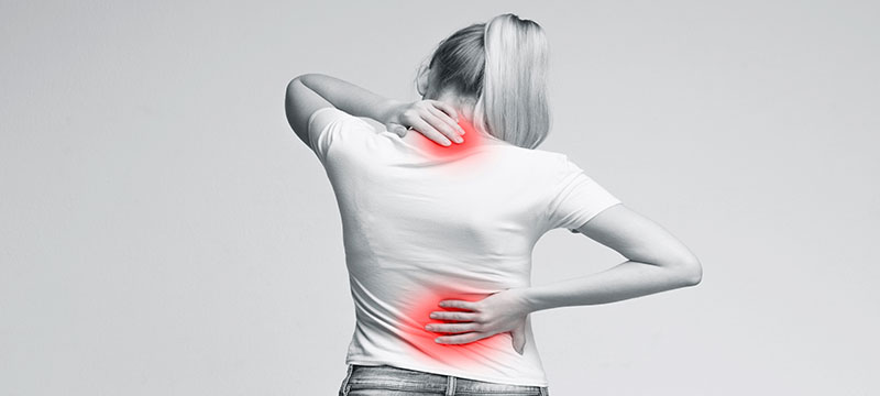 Woman rubbing her painful back, get back pain relief - Aarrow Straight Chiropractic Hudson NH